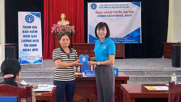 Cán bộ Bảo hiểm xã hội Hà Nội trao hỗ trợ chính sách an sinh xã hội cho người dân. (Ảnh: HSS)