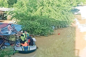 Lũ ngập đến mái nhà, lực lượng cứu hộ đón vợ anh Ngô Văn Hùng ở tổ 17, phường Phan Đình Phùng đến nơi an toàn. 