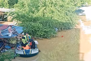 Lũ ngập đến mái nhà, lực lượng cứu hộ đón vợ anh Ngô Văn Hùng ở tổ 17, phường Phan Đình Phùng đến nơi an toàn. 