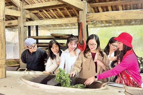 Du khách trải nghiệm sao trà bằng chảo gang.