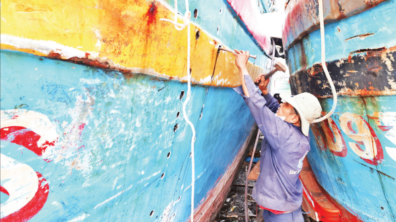 Ngư dân xã Đề Gi (tỉnh Gia Lai) đang tập trung sửa chữa tàu cá bị hư hỏng do bão số 13 để có thể sớm vươn khơi.