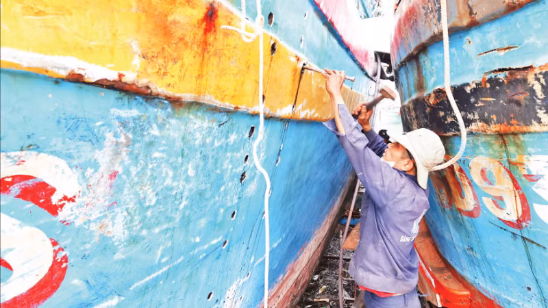 Ngư dân xã Đề Gi (tỉnh Gia Lai) đang tập trung sửa chữa tàu cá bị hư hỏng do bão số 13 để có thể sớm vươn khơi.