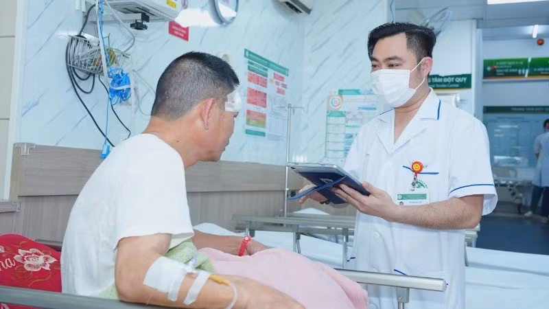 Nhân viên y tế Bệnh viện Bạch Mai sử dụng bệnh án điện tử trong quá trình thăm khám cho bệnh nhân.