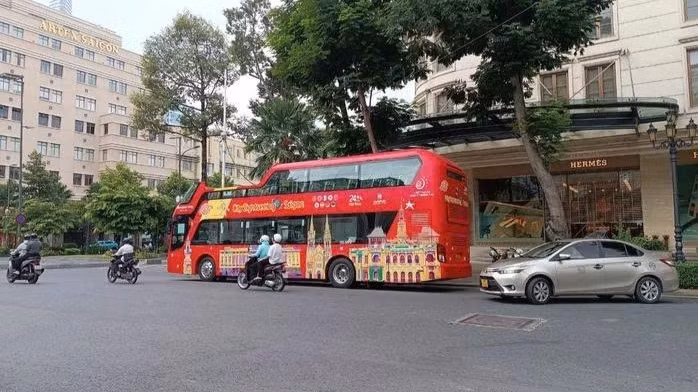 Xe buýt sử dụng ô-tô thoáng nóc chở khách du lịch tại trung tâm thành phố. (Ảnh: VÕ LÊ)