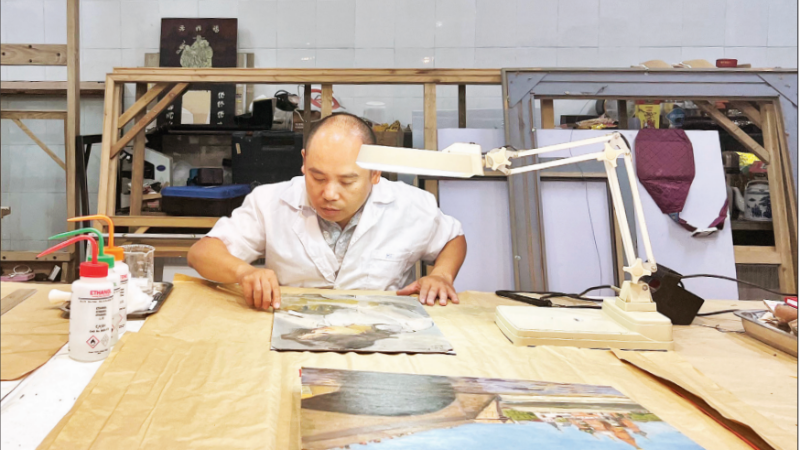 Ông Nguyễn Mạnh Hải làm sạch bức tranh của danh họa Trần Văn Cẩn.