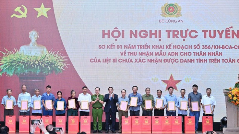 Thủ tướng Chính phủ Phạm Minh Chính trao Thông báo kết quả giám định ADN hài cốt liệt sĩ cho đại diện thân nhân các gia đình liệt sĩ. (Ảnh: TRẦN HẢI) 