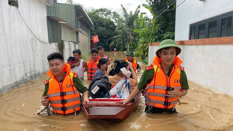Công an xã Anh Sơn (Nghệ An) phối hợp lực lượng chức năng dùng thuyền hỗ trợ người dân khỏi các khu vực sạt lở, nguy cơ ngập cao. (Ảnh: ANH VŨ)