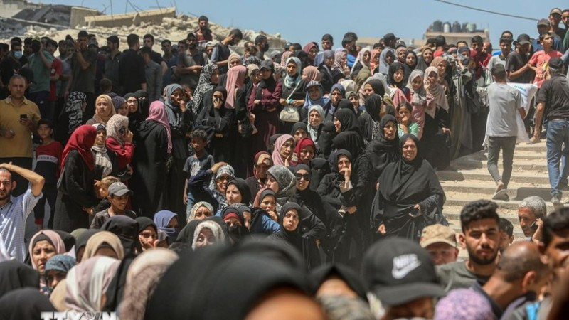 Người dân Palestine chờ được phát thực phẩm cứu trợ tại Gaza. (Ảnh: THX/TTXVN)