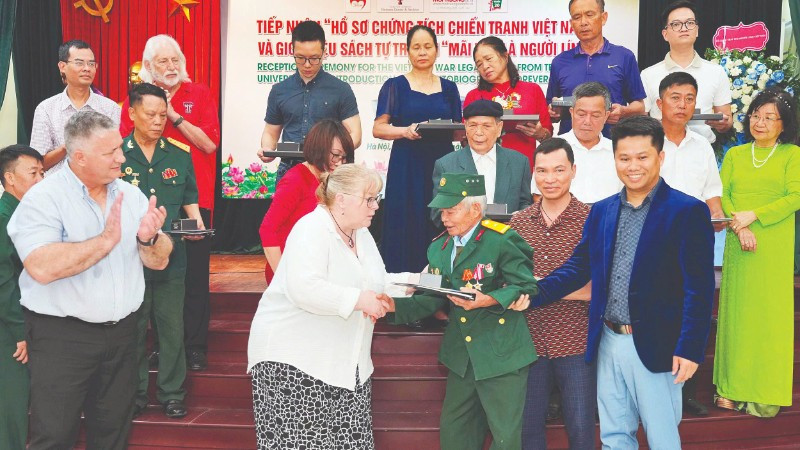 Đại diện Trường đại học Công nghệ Texas trao trả hồ sơ cho cựu chiến binh, thương binh Đỗ Xuân Thuyên.