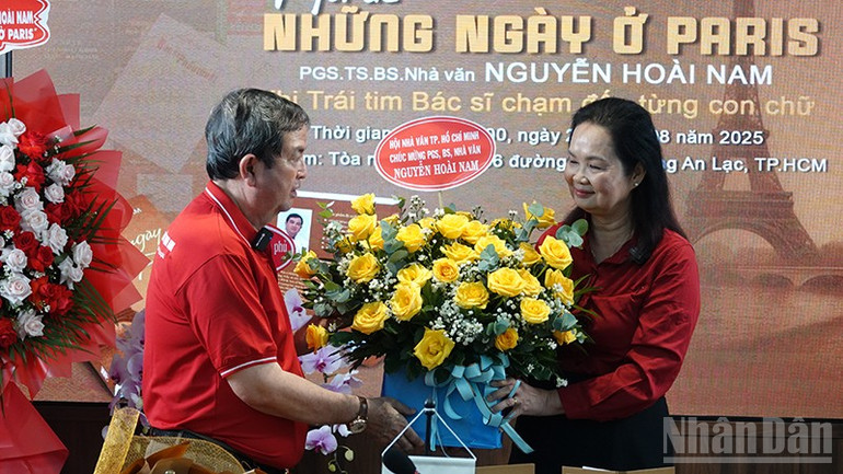 កប.អនឡាញ - នាព្រឹកថ្ងៃទី ២៤ សីហា អ្នកនិពន្ធ Bich Ngan ប្រធានសមាគមអ្នកនិពន្ធទីក្រុងហូជីមិញ បានប្រគល់កន្ត្រកផ្កា អបអរសាទរបណ្ឌិត និងអ្នកនិពន្ធ Nguyen Hoai Nam ក្នុងពិធីសម្ពោធសៀវភៅថ្មីរបស់គាត់ នាព្រឹកថ្ងៃទី ២៤ សីហា។ ndo_br_dsc00028.jpg