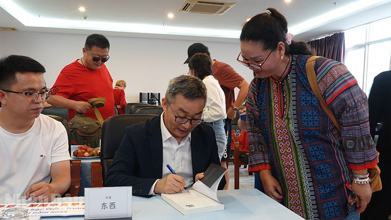 Nhà văn Đông Tây ký tặng sách cho bạn đọc. ndo_bl_dsc03838.jpg