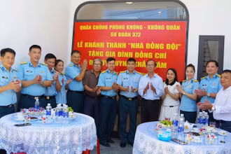 Các đại biểu dự buổi khánh thành và bàn giao “Nhà đồng đội” chụp ảnh lưu niệm với gia đình Đại úy Huỳnh Khắc Tâm. (Ảnh: VĂN TÂM)