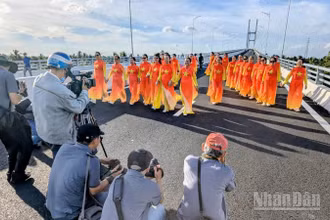 Người dân chụp ảnh lưu niệm trên cầu Rạch Miễu 2 trước ngày khánh thành, đưa vào sử dụng. (Ảnh: TRUNG HIẾU)