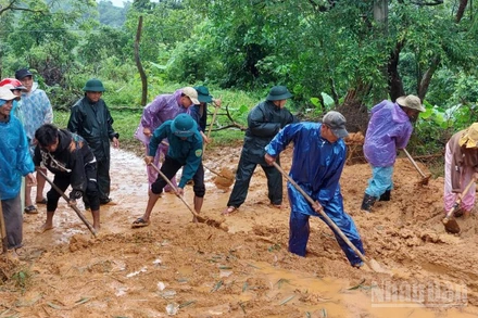 Bộ đội Biên phòng tỉnh cùng người dân dọn dẹp bùn đất trên các tuyến đường sau mưa lũ. 
