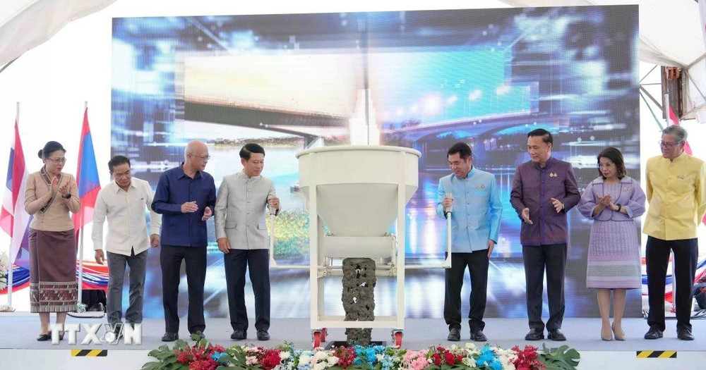 Phó Thủ tướng hai nước Lào-Thái Lan và đại diện các bộ, ngành hai nước thực hiện nghi thức đổ bê tông hợp long cầu. (Ảnh: XUÂN TÚ/TTXVN)