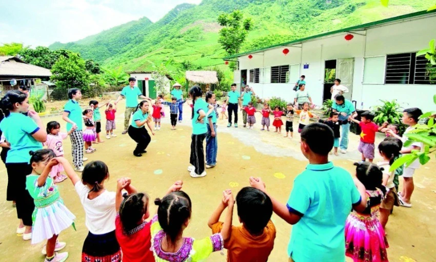 Các thành viên dự án “Đông ấm cho trẻ em vùng cao” cùng học sinh điểm trường Pa Phang 2, Trường mầm non Phìn Hồ (huyện Sìn Hồ, Lai Châu) bên hai lớp học mới khánh thành dịp Quốc tế Thiếu nhi. (Ảnh: PHONG CHƯƠNG)