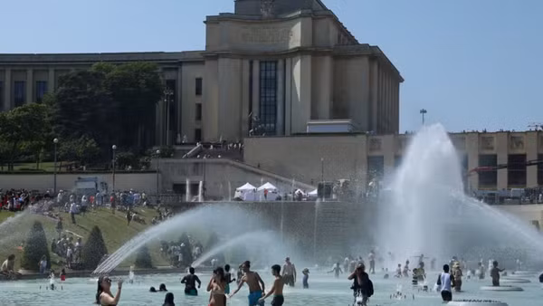 Người dân tránh nóng tại đài phun nước ở Paris, Pháp. (Ảnh: THX/TTXVN)