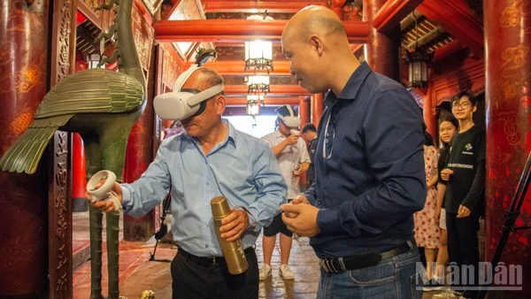 Khách du lịch thích thú khi được trải nghiệm hệ thống thực tế ảo tại di tích Văn Miếu-Quốc Tử Giám. (Ảnh: HÀ NAM)