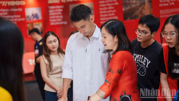 Du khách trải nghiệm sách tương tác tại Triển lãm "95 năm Cờ Đảng soi đường".