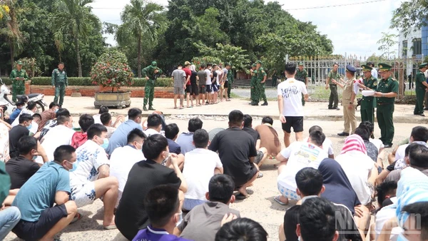 Lực lượng chức năng Việt Nam tiếp nhận các công dân liên quan tội phạm lừa đảo trực tuyến do phía Campuchia bàn giao tại khu vực cửa khẩu Mộc Bài. (Ảnh: ĐINH TRƯỜNG)