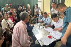 Cán bộ văn phòng Công ty cổ phần Cao-su Điện Biên chi trả tiền góp đất đến người dân trên địa bàn xã Mường Pồn, tỉnh Điện Biên.
