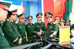 Đại tướng Phan Văn Giang kiểm tra khu trưng bày trong nhà của Bộ Quốc phòng tại Triển lãm thành tựu đất nước. (Ảnh VIỆT TRUNG)