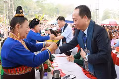 Bà con dân tộc Lào xã Na Sang thực hiện nghi thức buộc chỉ cổ tay để cầu may cho du khách về dự Tết té nước (Bun Huột nặm) của dân tộc Lào. 