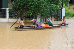 Người dân xã Đại Lộc sử dụng thuyền để di chuyển vì mưa lũ. (Ảnh: CÔNG VINH)