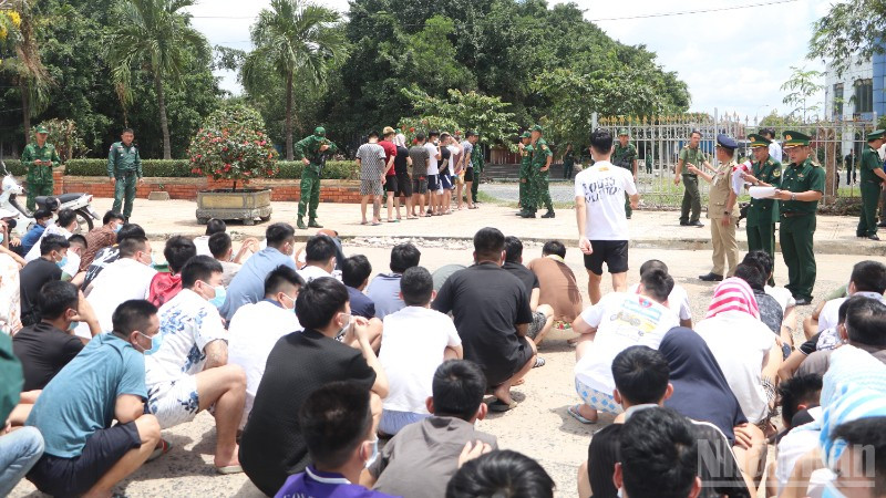 Lực lượng chức năng Việt Nam tiếp nhận các công dân liên quan tội phạm lừa đảo trực tuyến do phía Campuchia bàn giao tại khu vực cửa khẩu Mộc Bài. (Ảnh: ĐINH TRƯỜNG)