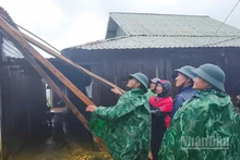 Các lực lượng chức năng hỗ trợ người dân xã Hùng Sơn lợp lại mái nhà bị tốc.