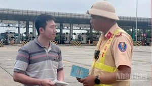 Cảnh sát giao thông tuyên truyền cho lái xe quy định mới về việc cấm xe tải lưu thông trên làn 1 tại tuyến cao tốc Pháp Vân-Cầu Giẽ.