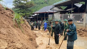 Bộ đội Biên phòng vùng thượng du Thanh Hóa xử lý đất, đá sạt từ ta luy xuống đường dân sinh. (Ảnh: Báo Nhân Dân)