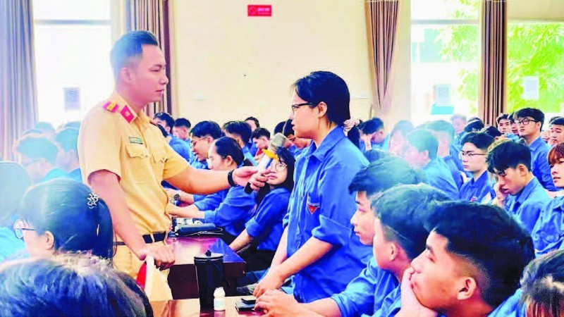 Lực lượng cảnh sát giao thông trao đổi, hướng dẫn các kỹ năng xử lý tình huống giao thông cho sinh viên tình nguyện. (Ảnh BẢO LÂM)