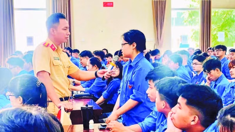 Lực lượng cảnh sát giao thông trao đổi, hướng dẫn các kỹ năng xử lý tình huống giao thông cho sinh viên tình nguyện. (Ảnh BẢO LÂM)
