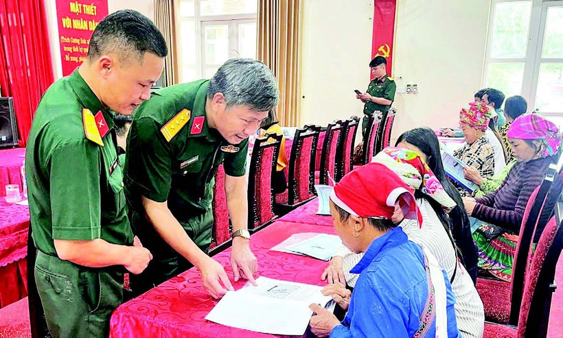 Cán bộ Đoàn Kinh tế-Quốc phòng 345 trao đổi, hướng dẫn người dân kỹ thuật chăn nuôi. (Ảnh QUANG PHẤN)