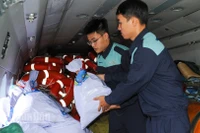 Cán bộ, chiến sĩ Sư đoàn Không quân 372 hiệp đồng chặt chẽ nhanh chóng vận chuyển hàng hóa cứu trợ lên trực thăng.