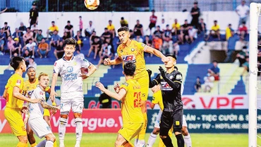 Pha tranh bóng giữa hai đội Thép Xanh Nam Ðịnh (áo trắng) và Ðông Á Thanh Hóa. (Ảnh VPF) 