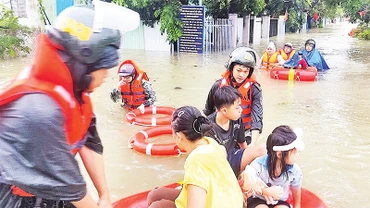 Cảnh sát cơ động Công an thành phố Ðà Nẵng di dời người dân Tổ 129, phường Hòa Minh, quận Liên Chiểu đi tránh lũ sáng 14/10. 