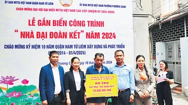 Ðại diện Ủy ban MTTQ - Ban vận động Quỹ "Vì người nghèo" quận Nam Từ Liêm trao hỗ trợ xây nhà "Ðại đoàn kết" tặng một hộ nghèo trên địa bàn. (Ảnh Trần Hòa) 
