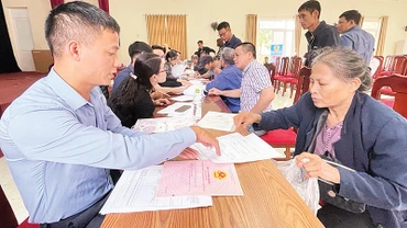 Cán bộ xã Vân Tảo hướng dẫn người dân thực hiện các thủ tục trước khi nhận tiền giải phóng mặt bằng. 