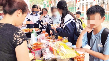 Hàng quà ăn vặt cho học sinh xuất hiện ở nhiều cổng trường học. (Ảnh TUẤN ANH) 