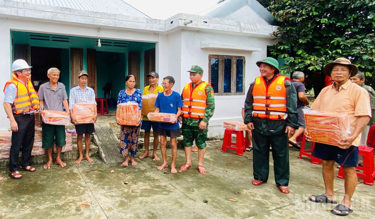 Cán bộ, chiến sĩ Đồn Biên phòng Bình Hải và Hải đội 2 cùng chính quyền địa phương hỗ trợ nhu yếu phẩm cho người dân vùng mưa lũ. ndo_br_4.jpg