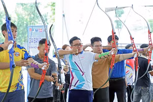 Thanh niên công nhân tranh tài bắn cung tại ngày hội.