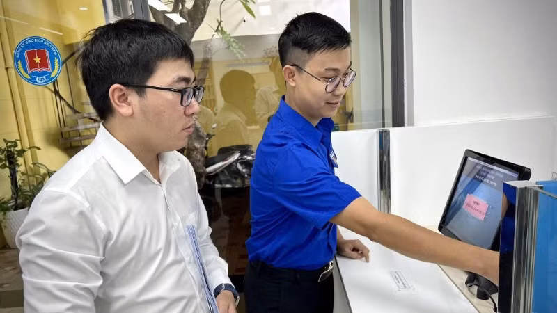 Cán bộ Trung tâm Đăng ký giao dịch, tài sản (thuộc Cục Đăng ký giao dịch bảo đảm và Bồi thường nhà nước, Bộ Tư pháp) hướng dẫn người dân làm hồ sơ trên Hệ thống đăng ký trực tuyến.