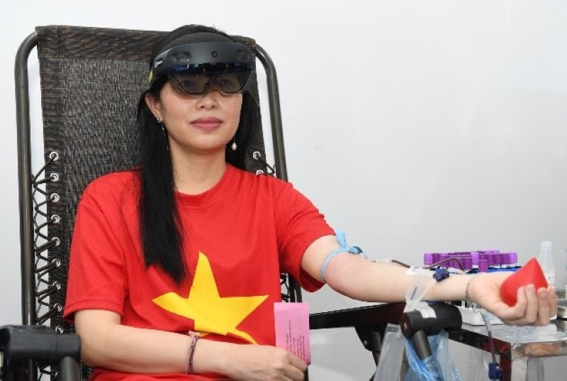 Chị Đoàn Thị Thanh Thủy trải nghiệm hiến máu khi đang đeo kính thực tế ảo tích hợp.