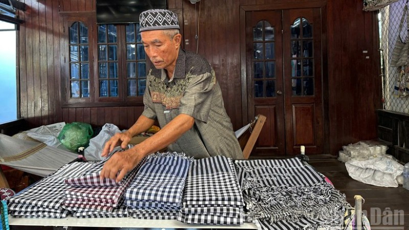 Ông Mohamad chăm chút cho từng sản phẩm dệt trưng bày tại cửa hàng.