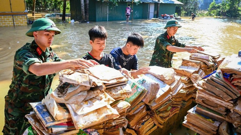 Bộ đội và học sinh đưa sách vở lên phơi trên nơi khô ráo tại Trường phổ thông dân tộc nội trú trung học cơ sở và trung học phổ thông Hữu Lũng, tỉnh Lạng Sơn. (Ảnh: THÀNH ĐẠT)