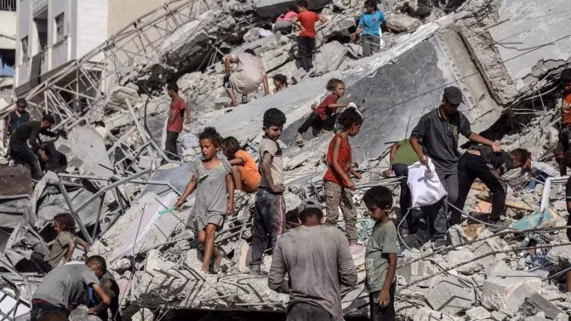 Người dân Palestine tại khu vực một tòa tháp bị phá hủy sau cuộc không kích của Israel vào thành phố Gaza ngày 6/9/2025. (Ảnh: XINHUA).