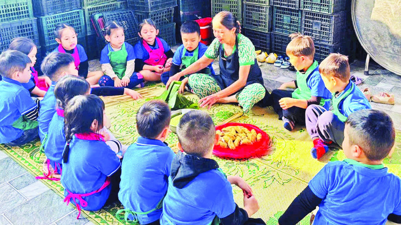 Học sinh đến trải nghiệm gói bánh tét mặt trăng ở làng Đại An Khê. (Ảnh: QUANG HUY)