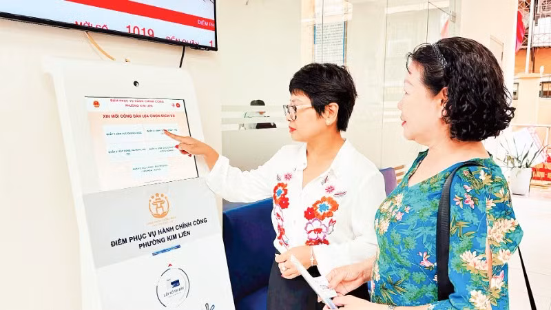 Hướng dẫn người dân lấy số thứ tự để thực hiện thủ tục hành chính tại Điểm tiếp nhận, phục vụ hành chính công phường Kim Liên (Hà Nội). (Ảnh: NGUYÊN BẢO)
